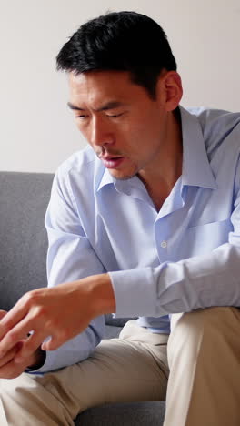 Man-using-mobile-phone-while-sitting-on-sofa