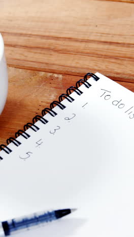 Close-up-of-coffee-cup-with-diary-and-pen