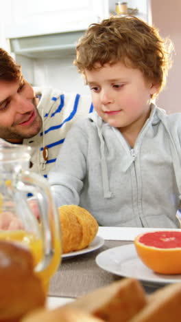 Father-and-son-having-breakfast-in-the-kitchen