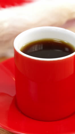 Close-up-of-coffee-cup-with-saucer-and-santa-hat