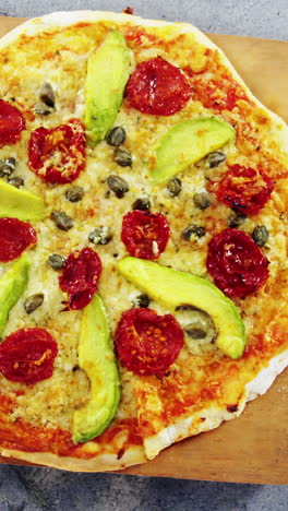 Baked-pizza-with-avocado,-cherry-tomato-and-olive-toppings