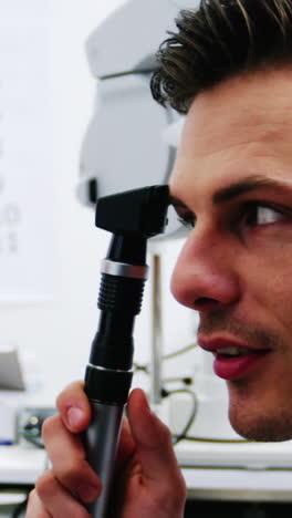 Close-up-of-optometrist-looking-through-ophthalmoscope