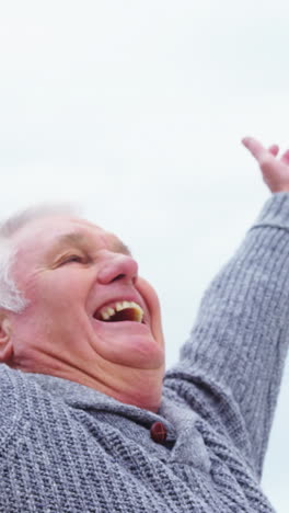 Happy-senior-woman-standing-on-the-beach