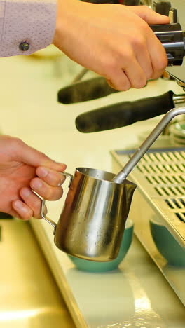 Mid-section-of-waiter-making-espresso