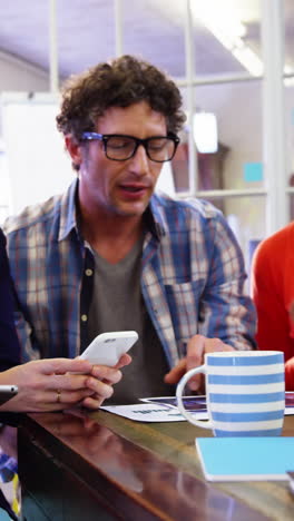 Group-of-business-executives-interacting-over-digital-tablet-and-mobile-phone