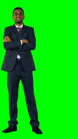 Businessman-standing-with-arms-crossed-against-green-background