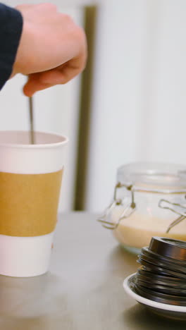 Waiter-making-cup-of-coffee-on-steel-table