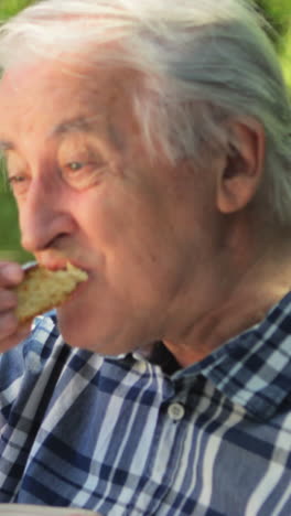 Senior-man-eating-sweet-food-in-garden