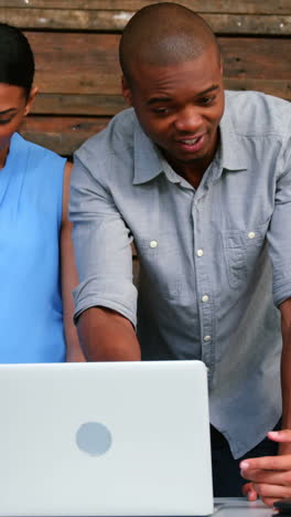 Business-executives-discussing-over-laptop