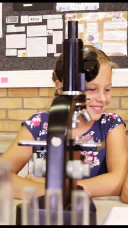 Niños-De-Escuela-Mirando-A-Través-Del-Microscopio-En-El-Laboratorio