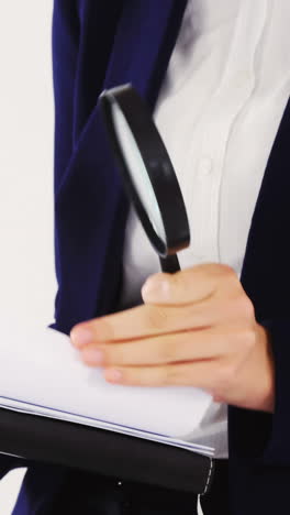 Businesswoman-checking-document-with-magnifying-glass