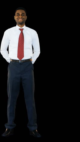 Businessman-standing-and-smiling-against-black-background