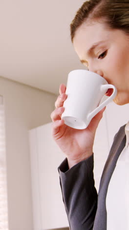 Mujer-Tomando-Café-En-La-Cocina