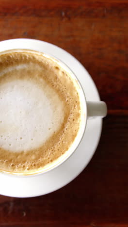 Cup-of-coffee-with-saucer-and-spoon-on-table