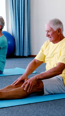 Senior-citizens-performing-stretching-exercise