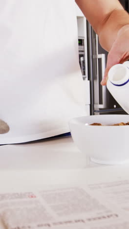 Man-preparing-cereals-for-breakfast-in-kitchen