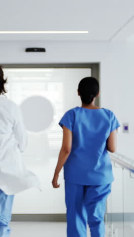 Doctor-and-nurse-running-in-passageway-of-hospital