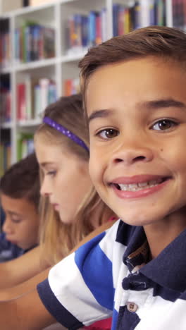 Schoolboy-drawing-in-book-in-classroom