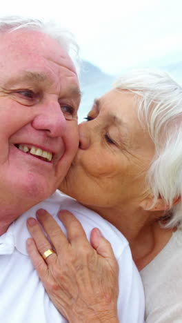 Senior-couple-embracing-each-other-on-the-beach