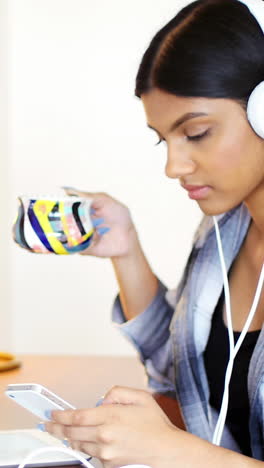 Mujer-Usando-Teléfono-Móvil-Mientras-Toma-Una-Taza-De-Café