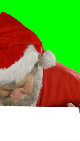 Surprised-santa-claus-hiding-behind-green-screen