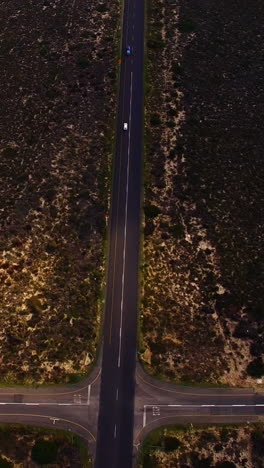 Aerial-view-of-a-dirt-road-winding-around-rural-field