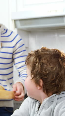 Father-talking-on-mobile-phone-while-son-using-digital-tablet