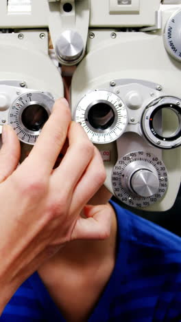 Female-optometrist-examining-young-patient-on-chiropter