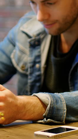 Mann-Benutzt-Digitales-Tablet-Mit-Einem-Glas-Saft-Auf-Dem-Tisch