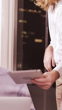 Businesswoman-discussing-with-colleagues-over-laptop