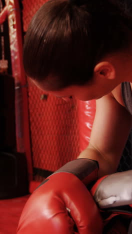 Tired-female-boxer-sitting-in-the-ring