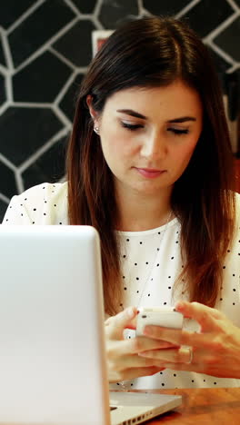 Attentive-businesswoman-using-mobile-phone