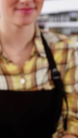 Portrait-of-waitress-standing-at-counter-with-desserts