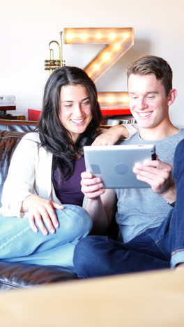 Couple-using-digital-tablet-in-living-room