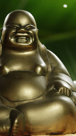 Close-up-of-laughing-buddha-figurine-with-falling-pearl