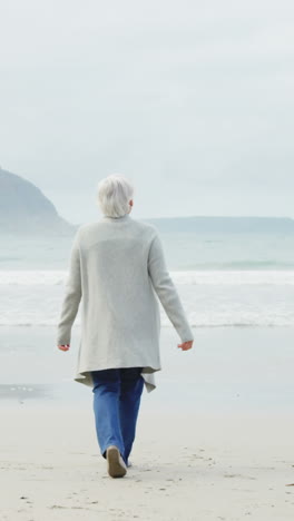 Rückansicht-Einer-älteren-Frau,-Die-Am-Strand-Spaziert