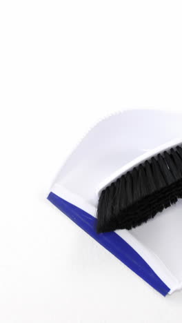 Dustpan-and-sweeping-brush-on-white-background