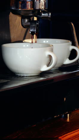 Waitress-making-cup-of-coffee-at-counter-in-kitchen