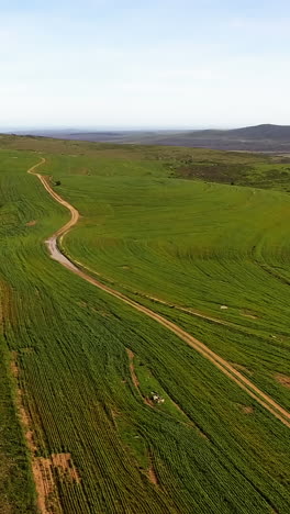 Aerial-view-of-a-dirt-road-winding-through-mountainous-terrain