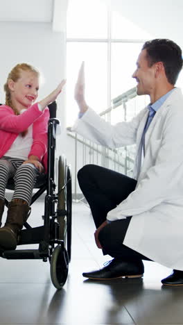 Doctor-giving-high-five-to-disable-girl