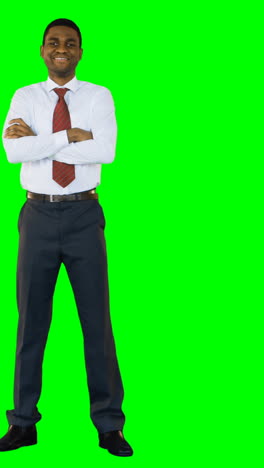 Businessman-standing-with-arms-crossed-against-green-background