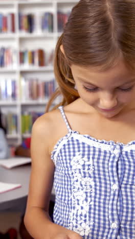 Schoolgirl-using-digital-tablet-in-library