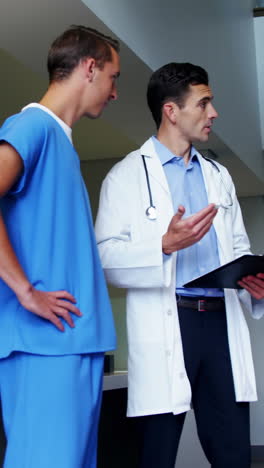 Doctors-discussing-over-clipboard