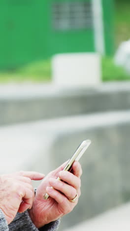 Senior-man-using-mobile-phone-on-beach