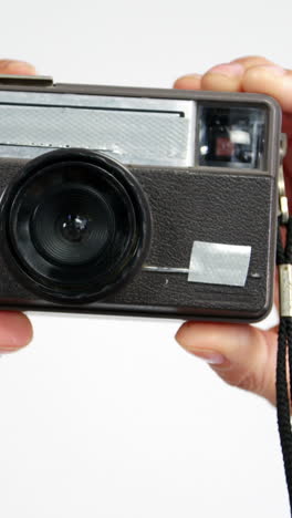 Close-up-of-photographer-taking-photo-with-vintage-camera