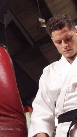 Man-in-black-belt-standing-in-fitness-studio