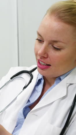 Smiling-female-doctor-explaining-patient-on-clipboard