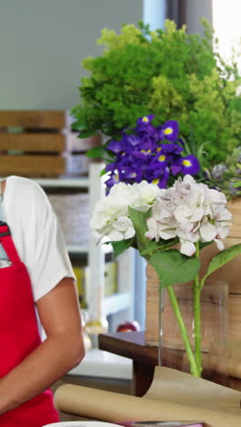 Female-staff-assisting-man-in-selecting-flower-bouquet