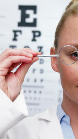 Female-optometrist-looking-through-magnifying-glass