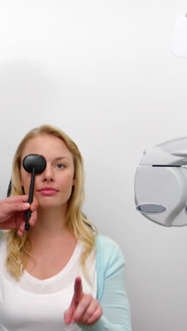 Optometrist-examining-female-patient-with-medical-equipment